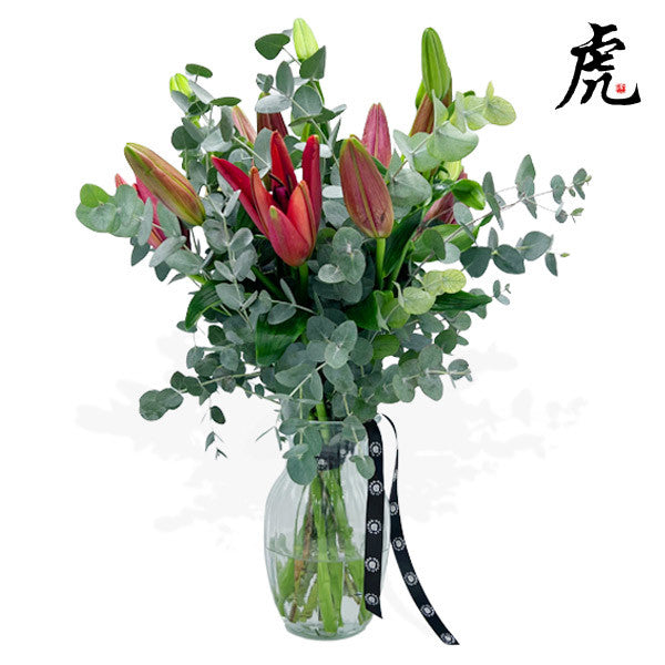 Hand-tied bouquet with red oriental lilies and eucalyptus greenery.